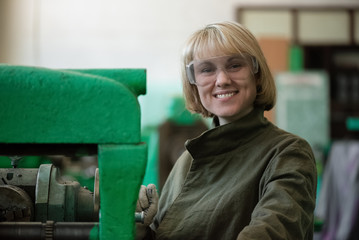 Happy woman worker near old milling machine.