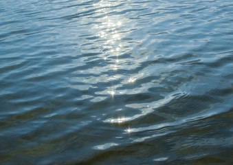 Sun glare on the water. Blue water summer background. Blur.