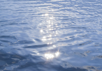 Sun glare on the water. Blue water summer background. Blur.