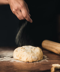 baker kneading dough on wooden table