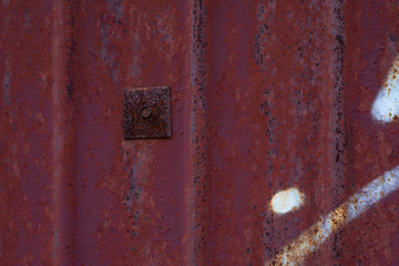 Texture of rusty metal surface with a patch. An old rusty sheet of iron with an old bolt corroded by rust and weather. Textured effect background for design