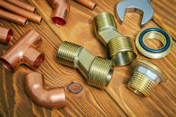 Spare parts with copper and brass accessories for plumbing repair on vintage wooden board