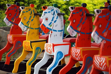 A row of colourful wooden rocking horse on display outside the store on Mysore road - Powered by Adobe