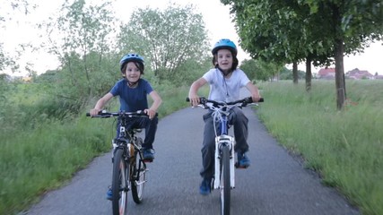 Children, boys, riding bikes  together summer time on a rainy day