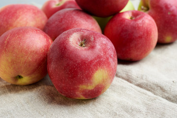 bunch of red ripe apples lies on a gray linen napkin