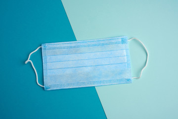 blue disposable medical mask on a blue background