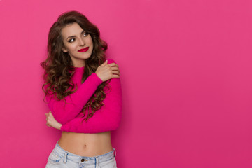 Beautiful Young Woman In Pink Sweater Is Looking Away