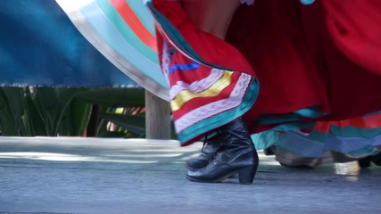 Latino women in colourful traditional dresses dancing Jarabe tapatio, mexican national folk hat dance. Street performance of female hispanic ballet in multi colored ethnic skirts. Girls in costumes. - Powered by Adobe