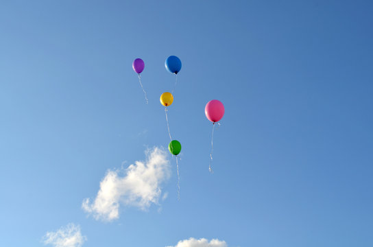 Five multicolored balloons in the blue sky. Balloons in the sky. Holiday