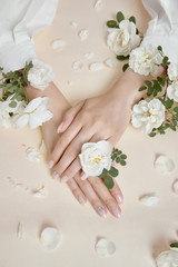 Fototapeta na wymiar Beauty hands woman with rose flowers are on the table. Natural cosmetic for hand skin care. Fashion makeup