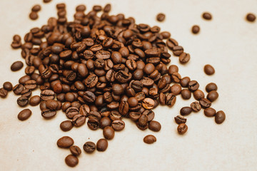Coffee bean background. Dark-colored roasted coffee beans scattered on Kraft paper.