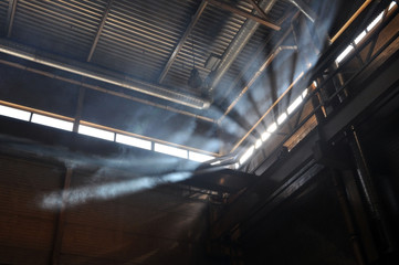 Smoke in the rays of sunlight in the production area of the plant.