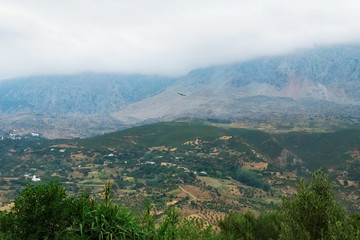 Naklejka premium Moroccan landscape with foggy mountains and fields.