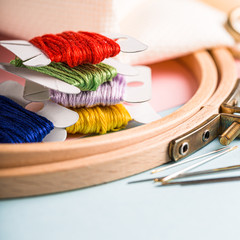 Embroidery set fot cross stitching. White fabric, embroidery hoop, colorful threads, scissors and...