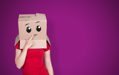 Person with cardboard box on its head and a thoughtful face expression on purple background