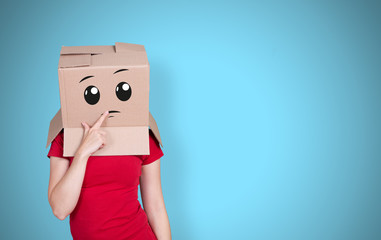Person with cardboard box on its head and a thoughtful face expression on light blue background