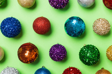 Top view of colorful Christmas balls on green background. New Year time concept
