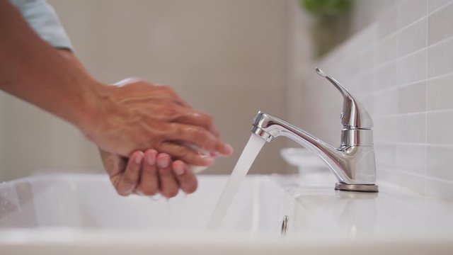 Men's hands wash hands with soap and a sink with a running tap. Wash hands to stop the spread of the coronavirus or virus and bacteria. Good health