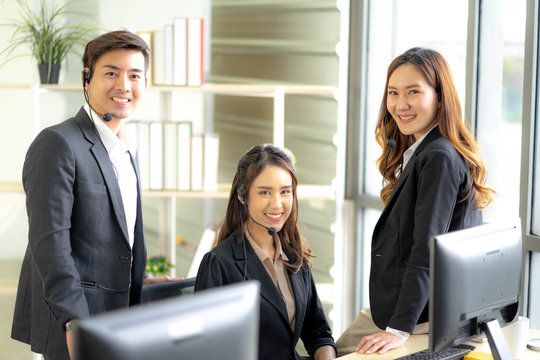 Asia Group of call center workers or Confident business team with headset. Technical support operators concept.