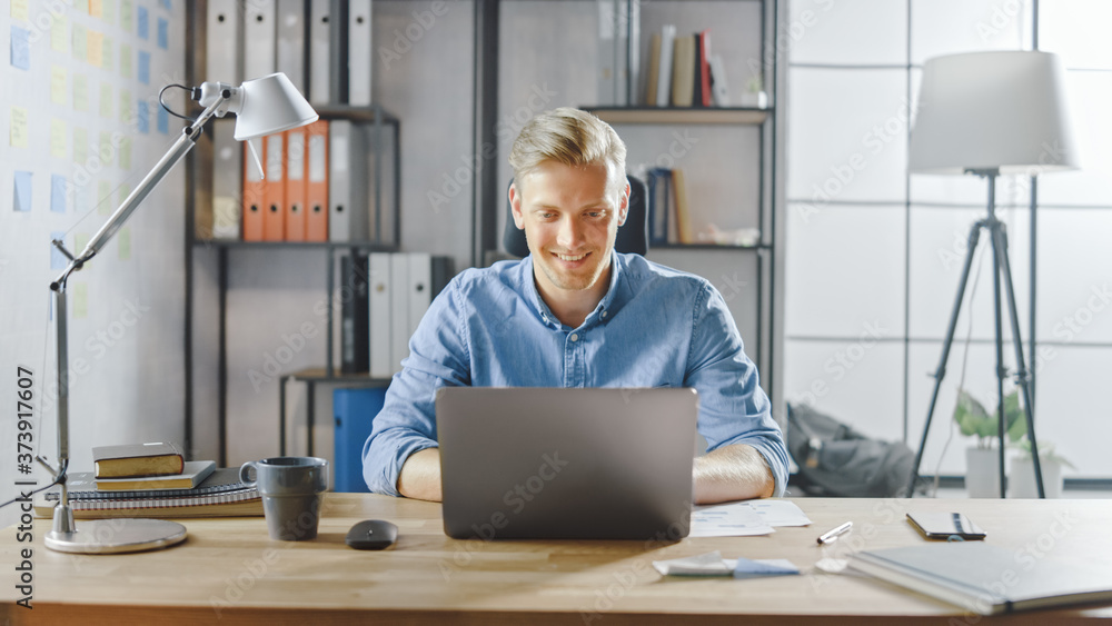 Wall mural creative entrepreneur sitting at his desk works on a laptop in the stylish office, uses software for