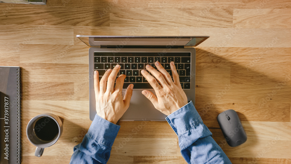 Poster top view close-up shot of a man's hands typing on a laptop keyboard. bright and modern theme.