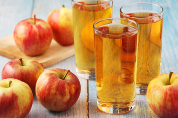 Glasses with apple juice and ripe apples
