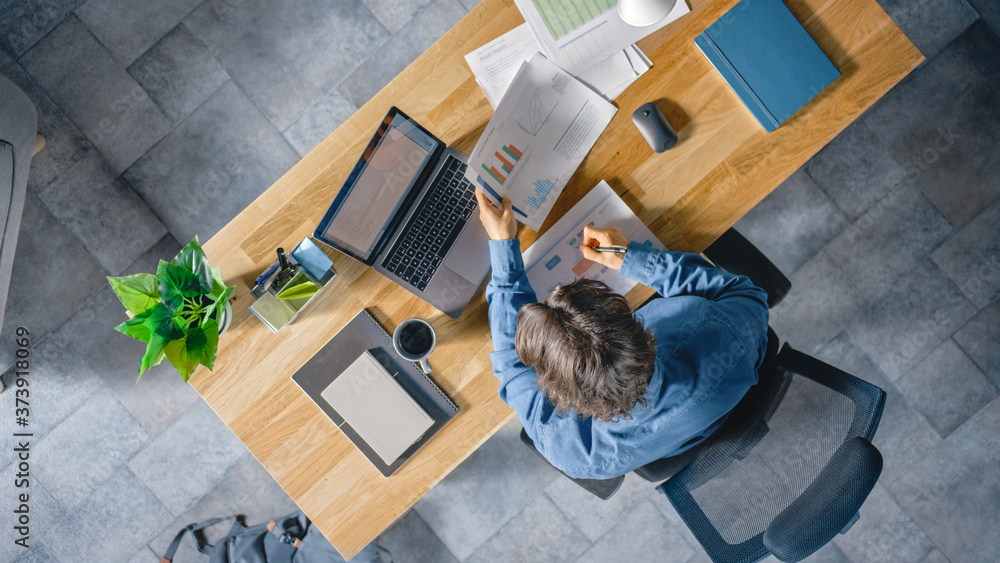 Poster businessman sitting at his desk in the office uses laptop computer, working with company strategy do