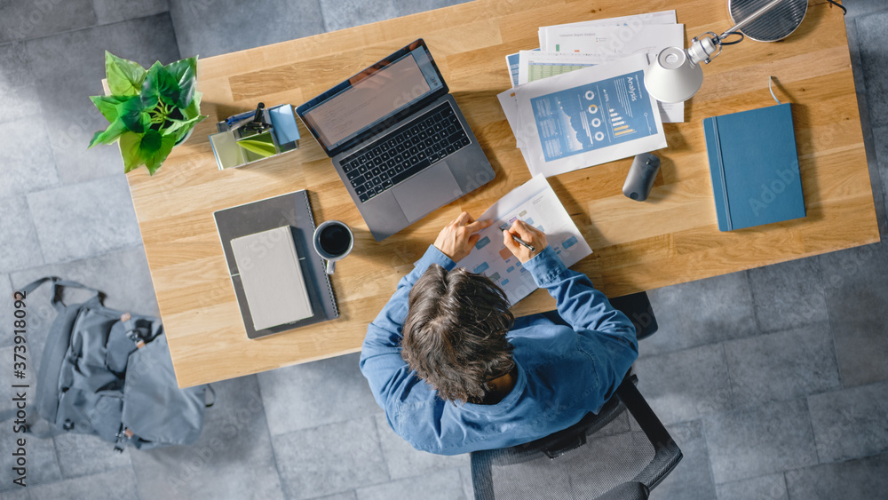Poster businessman sitting at his desk in the office uses laptop computer, working with company strategy do