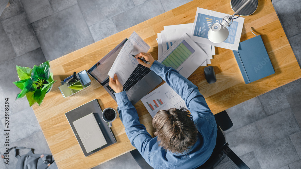Poster businessman sitting at his desk in the office uses laptop computer, working with company strategy do