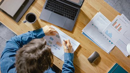 Businessman Sitting at His Desk in the Office Uses Laptop Computer, Working with Company Strategy...