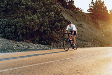 Professional cyclist on a mountain road at sunrise