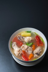 Clear chicken soup in a white bowl