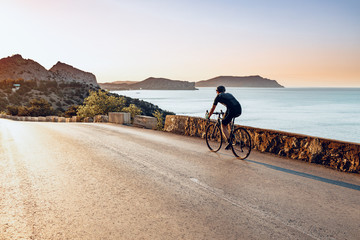 Cycling sport athlete man riding on coastal road