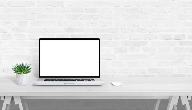Laptop on white desk with isolated screen for website or app design promotion. Free space beside for promo text