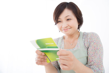 預金通帳を見る主婦