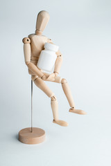 Wooden man holds  jar with pills in his hands. Isolate on white background. Advertising of tablets. Place for text. 
Corona virus cure. 
Mockup pharmaceutical concept