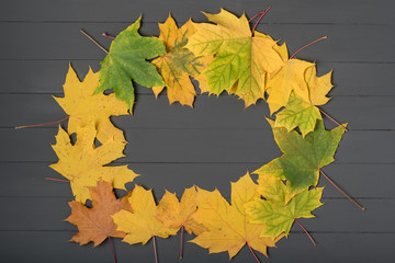 Yellow leaves folded in shape of frame on gray wooden background. Template. Backdrop. Mockup