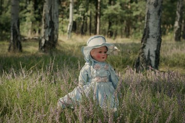 An Antique Doll Standing In The Fairytale Birch Forest During The Late Summer Afternoon 