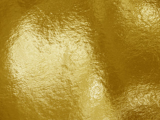 Gold foil background with highlights and uneven texture