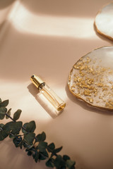 Travel size perfume bottle on warm pastel and golden table