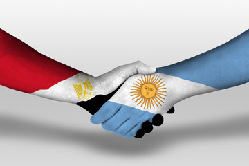 Handshake between argentina and egypt flags painted on hands, illustration with clipping path.