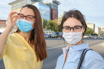 two girls in glasses and protective masks