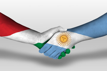 Handshake between argentina and hungary flags painted on hands, illustration with clipping path.