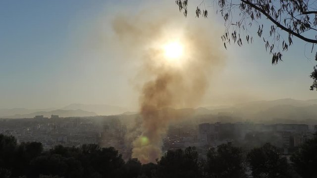 Fire in the city of Malaga Spain with very high smoke and firefighters trying to put it out