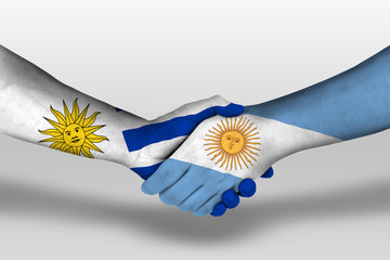 Handshake between argentina and uruguay flags painted on hands, illustration with clipping path.