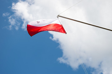 The white-red Polish flag against the blue sky