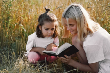 Girls reading holy bible in a wheat field. Study the holy bible together