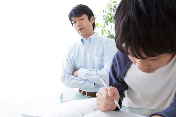 勉強する息子と教える父