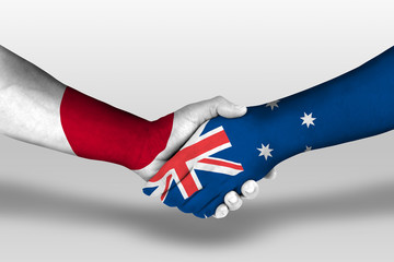 Handshake between Australia and Japan flags painted on hands, illustration with clipping path.