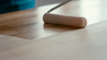 Close Up Shot of Wood Treatment: Roller with Oil used for Oak Table Renovation